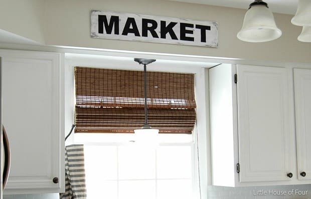 Custom farmhouse diy projects sign hung over a sink in a kitchen with rustic touches and bright light