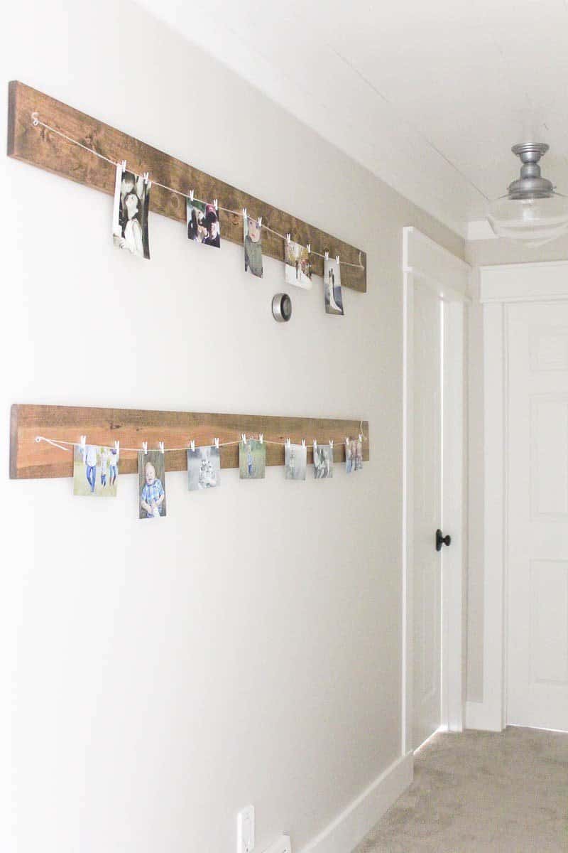 Rustic farmhouse diy picture hanging system using barnwood and as part of a projects list to create a farmhouse look