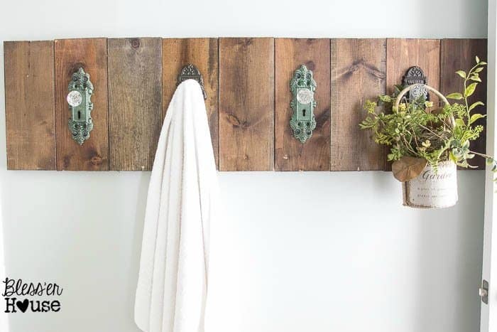 knobs hung up on barnwood in a living room to hang towels and plants to give a rustic feel