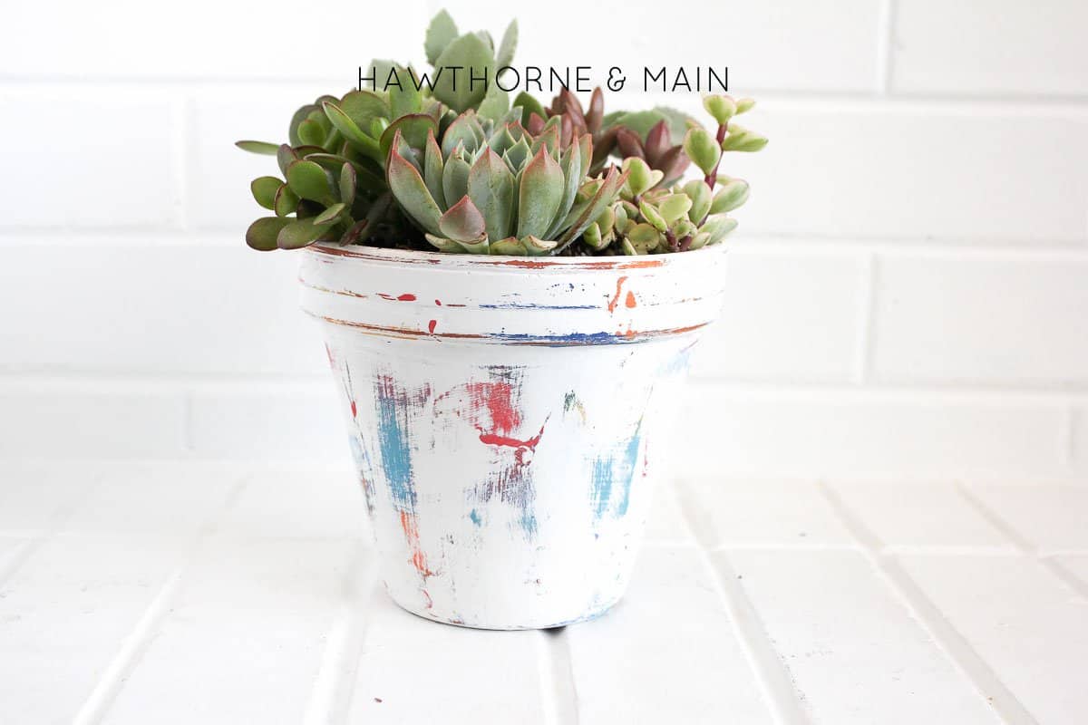 Painted potted plant with multiple colors then distressed to give it a farmhouse look and is a great project