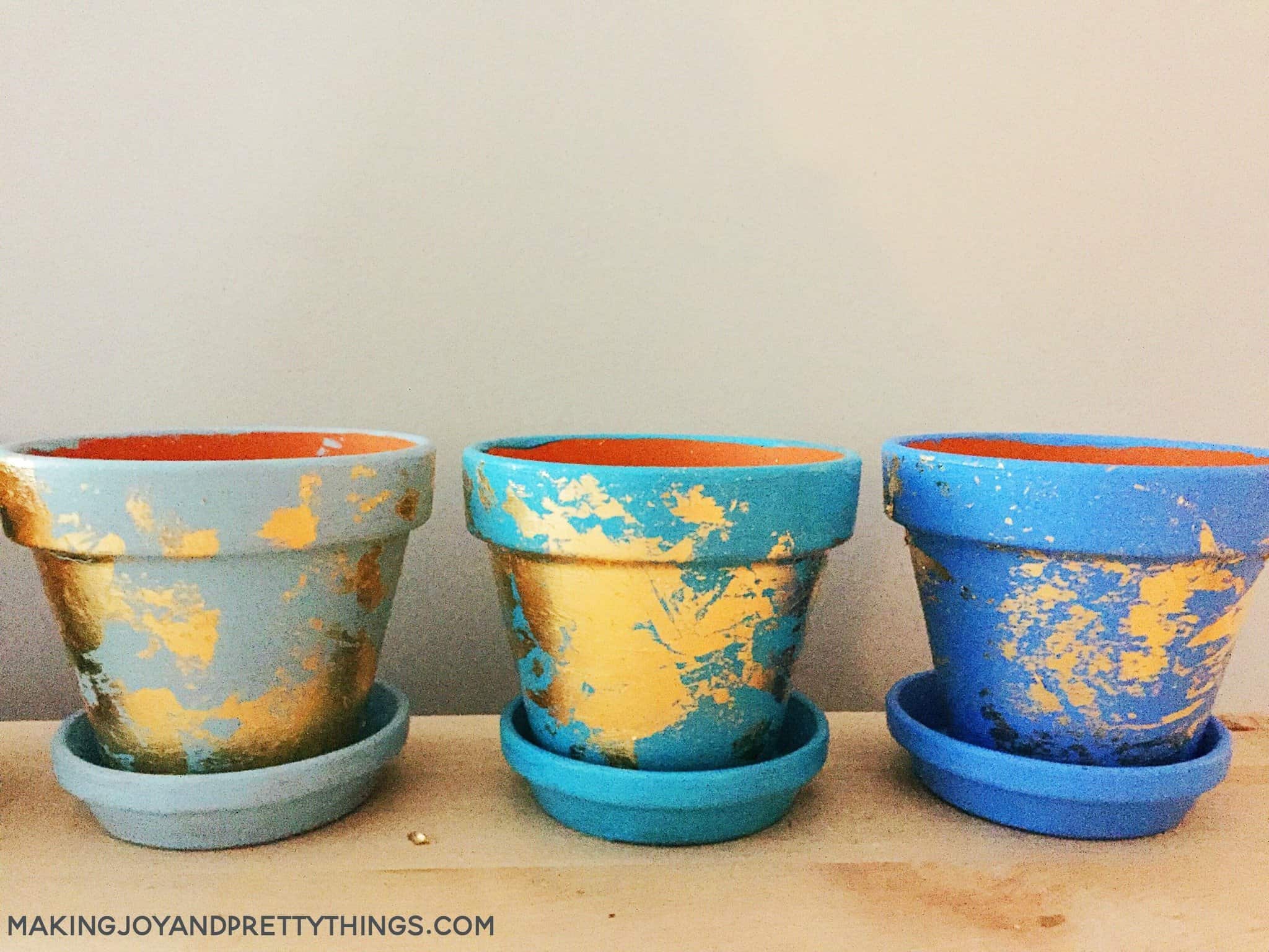 Finished blue painted clay pots finished off with gold foil to create a gold leaf planter for plants