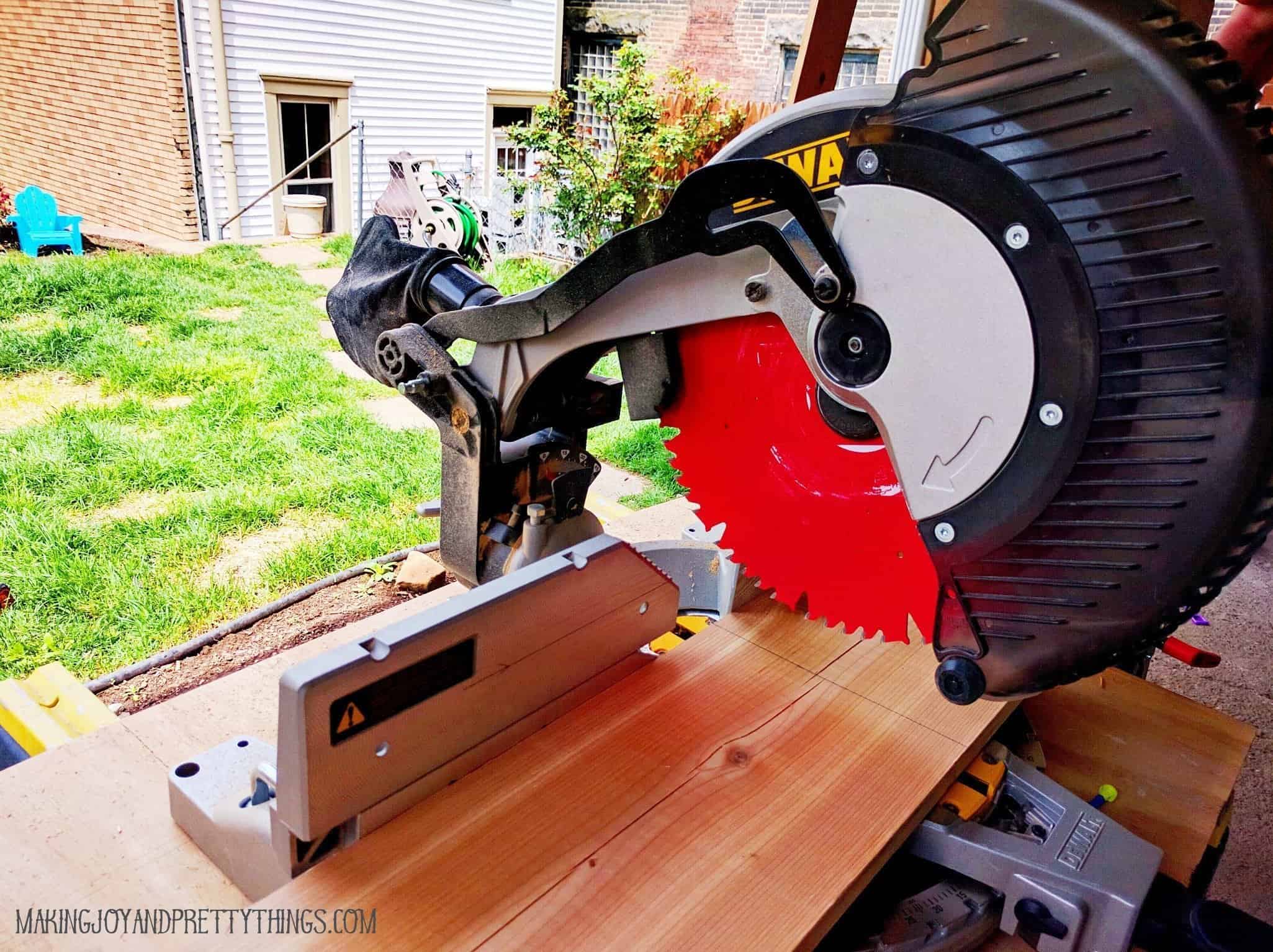 Using a compound miter saw to cut a cedar plank board for a raised garden bed how to 
