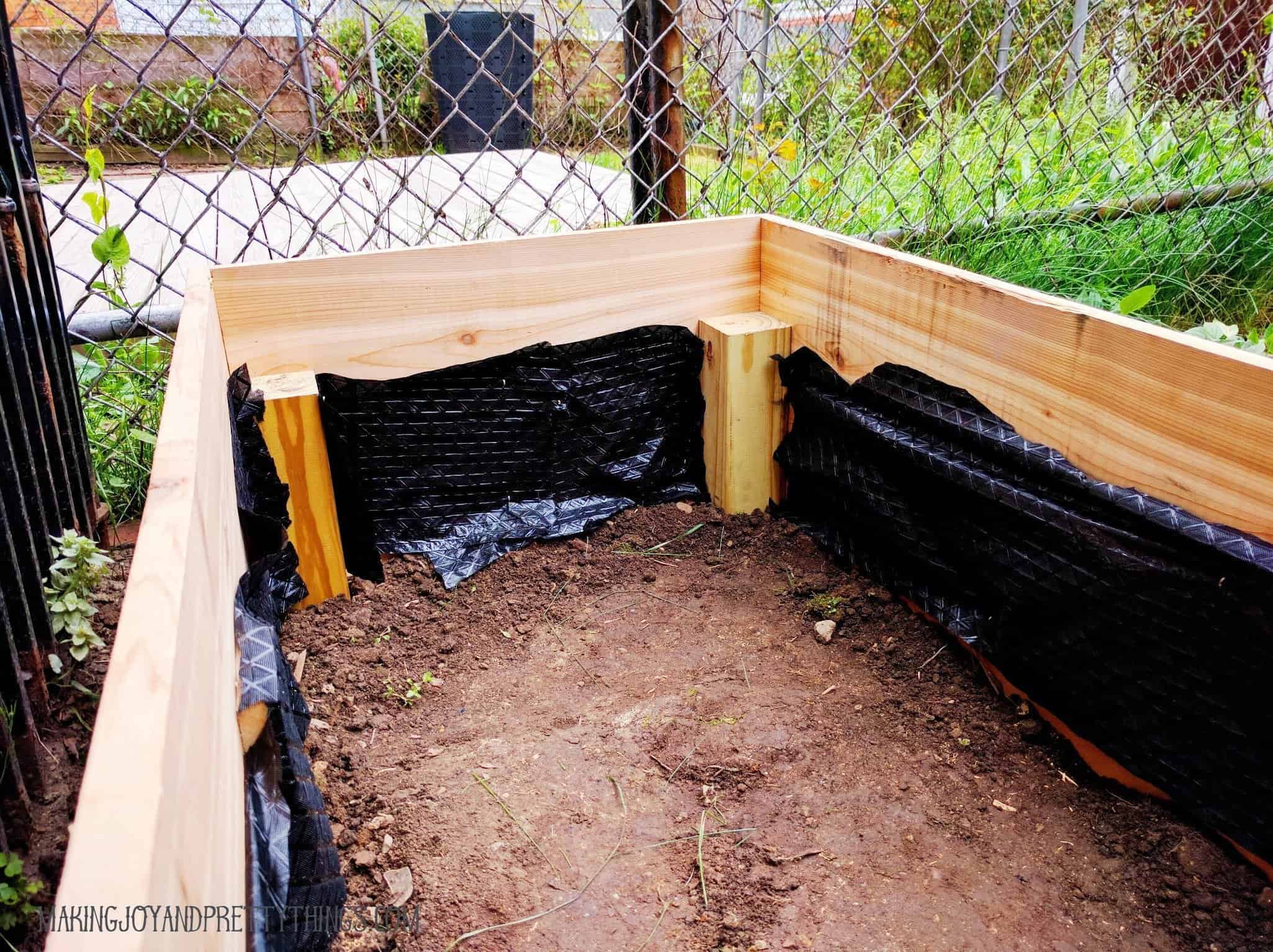 Using weed block to prevent dirt and roots from seeping out of the sides of the cedar raised garden bed