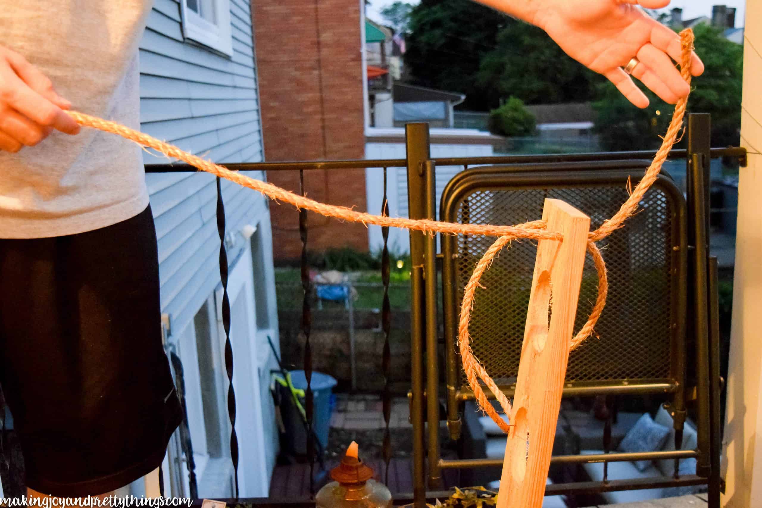 Tying a knot through a cedar board to have a spot on the rope for the garden to stop and hang out