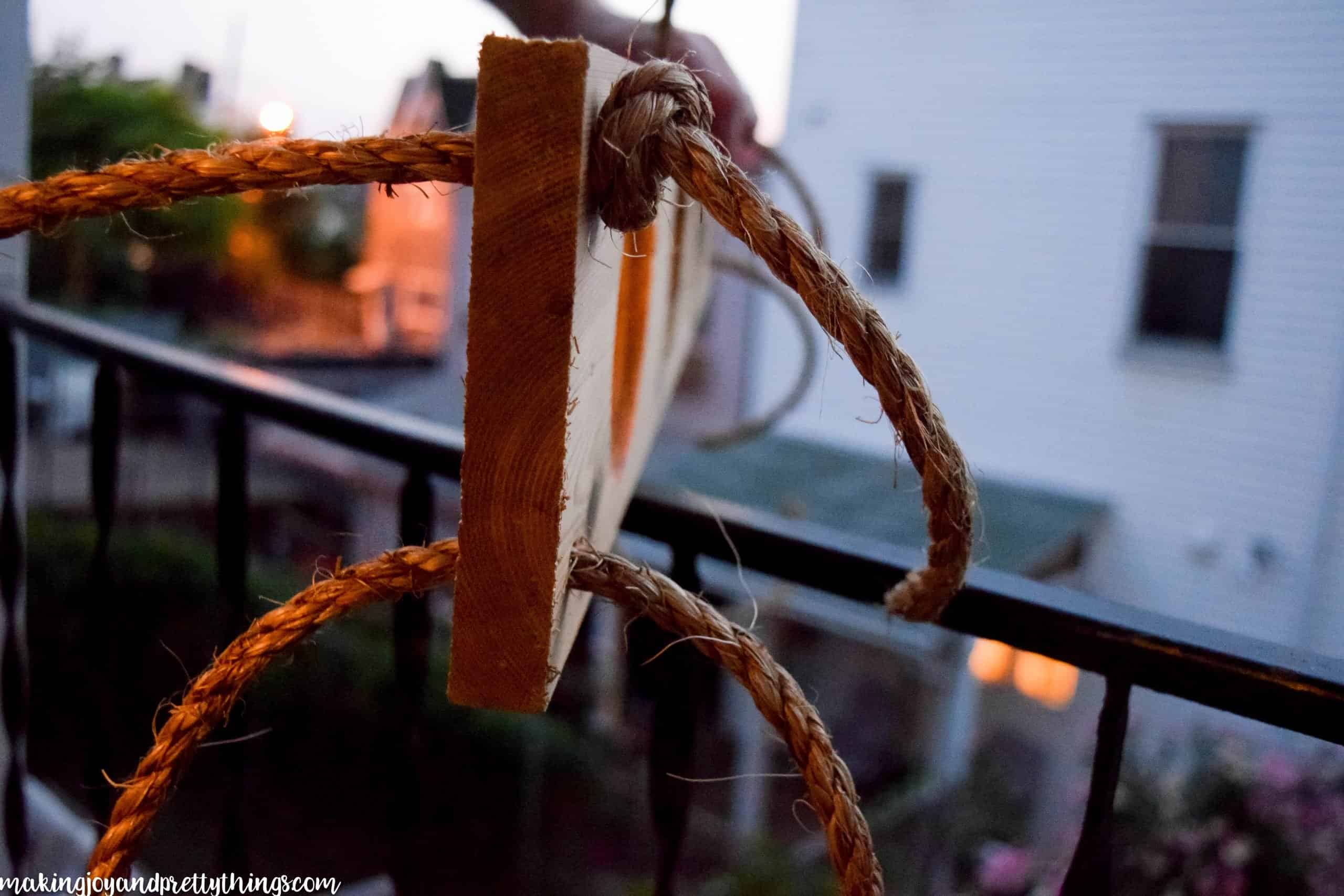 Showing a knot tied for a DIY that is going hang up a board for a garden on a balcony 