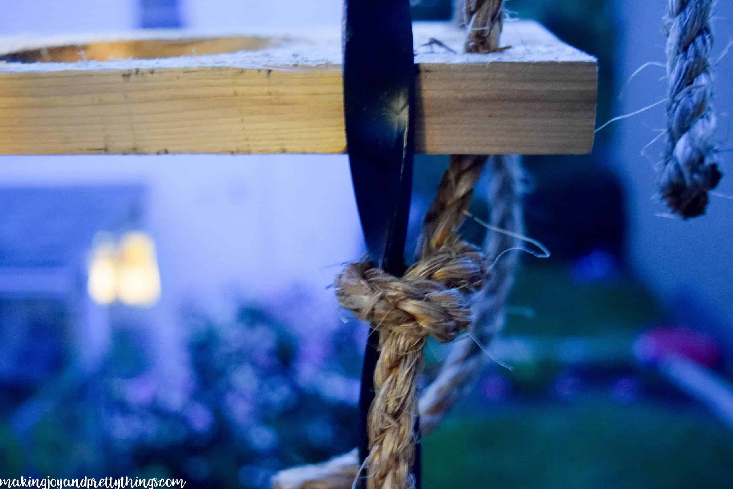 Securing the bottom of the herb garden  with rope to a balcony railing and plants