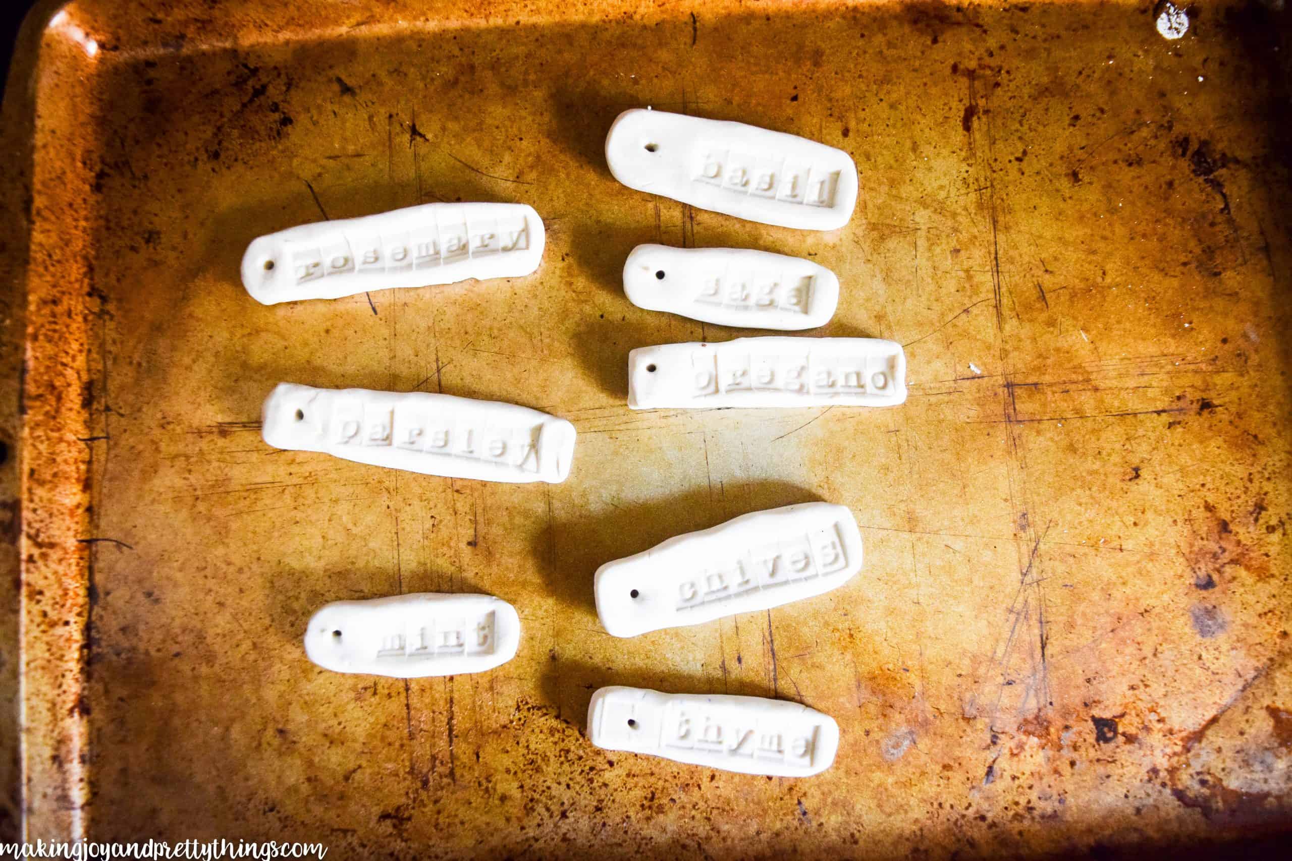 Stamped and lettered clay ready to be baked in the oven with tag holes ready to harden