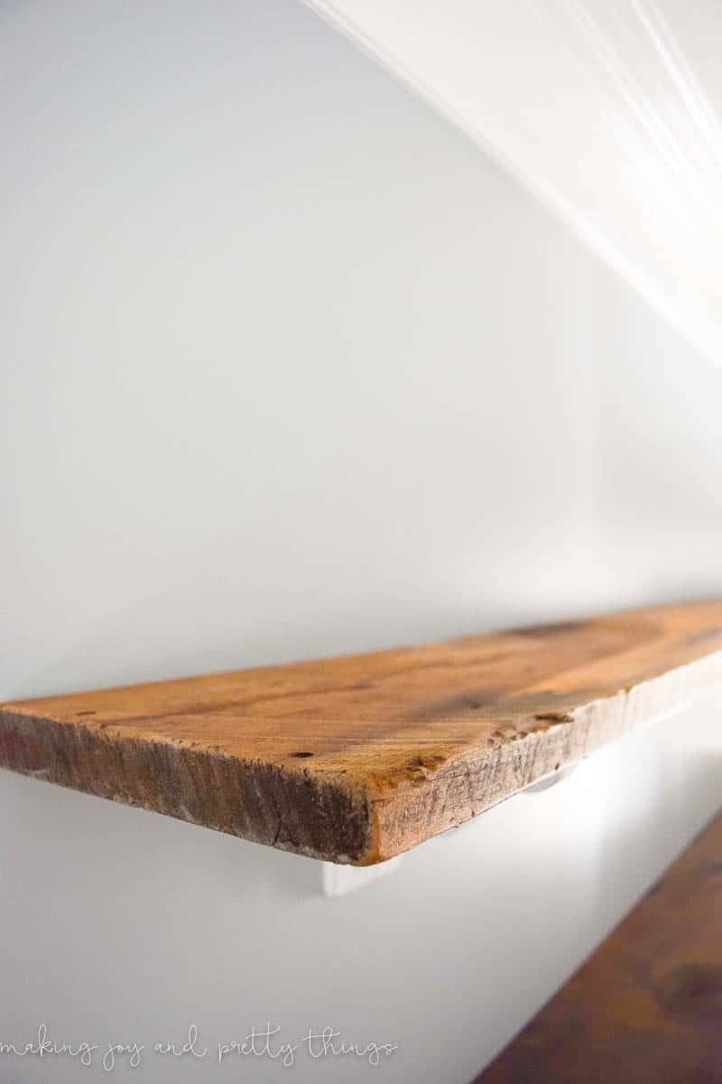 Close up of DIY farmhouse shelves that have been cleaned up and hung on distressed corbels