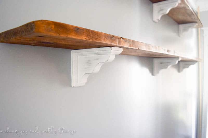DIY farmhouse shelves with distressed corbels give a great look and shelf space to decorate in a room