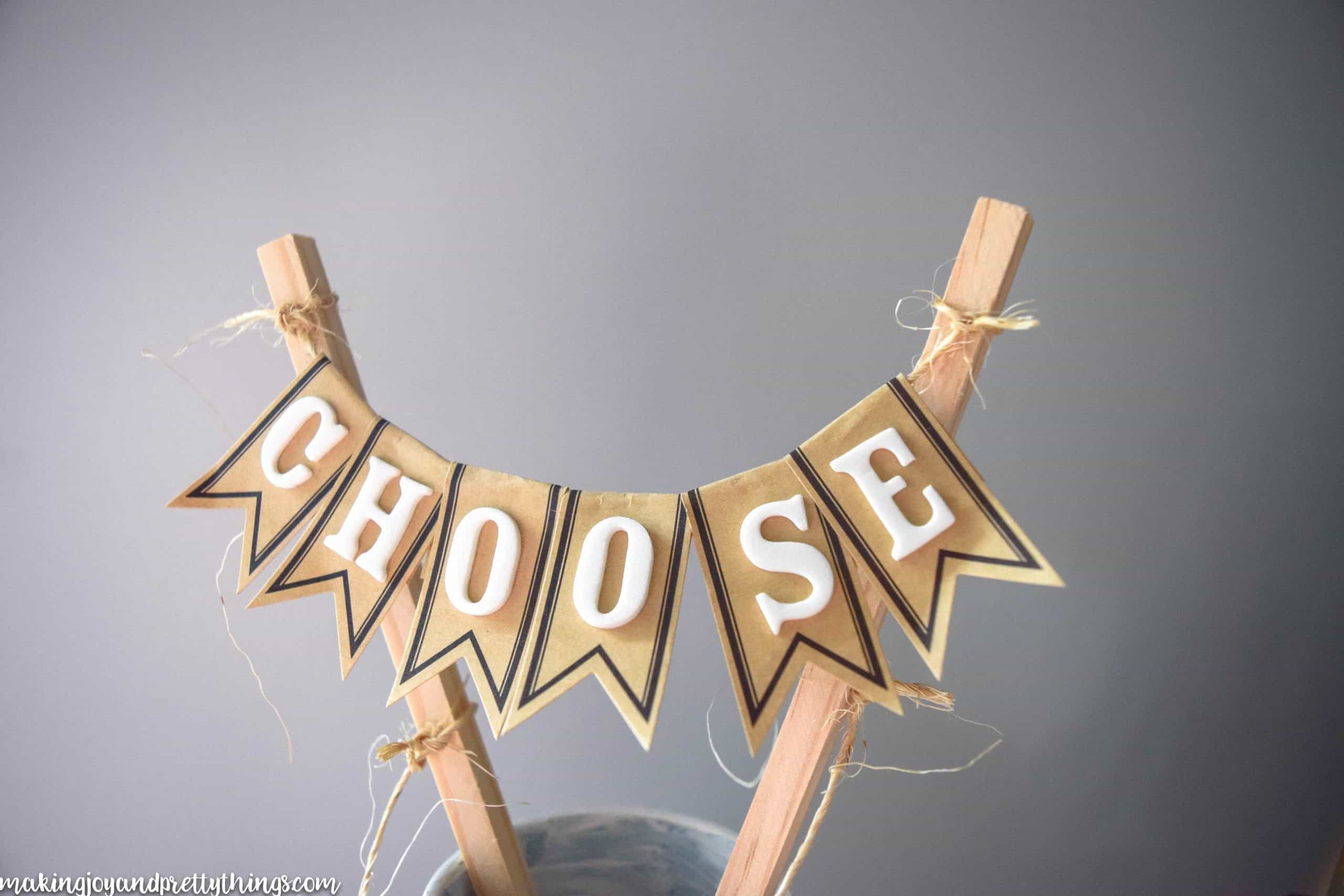Foam lettering on labels spelling the word choose strung across two dowels to get a farmhouse feel