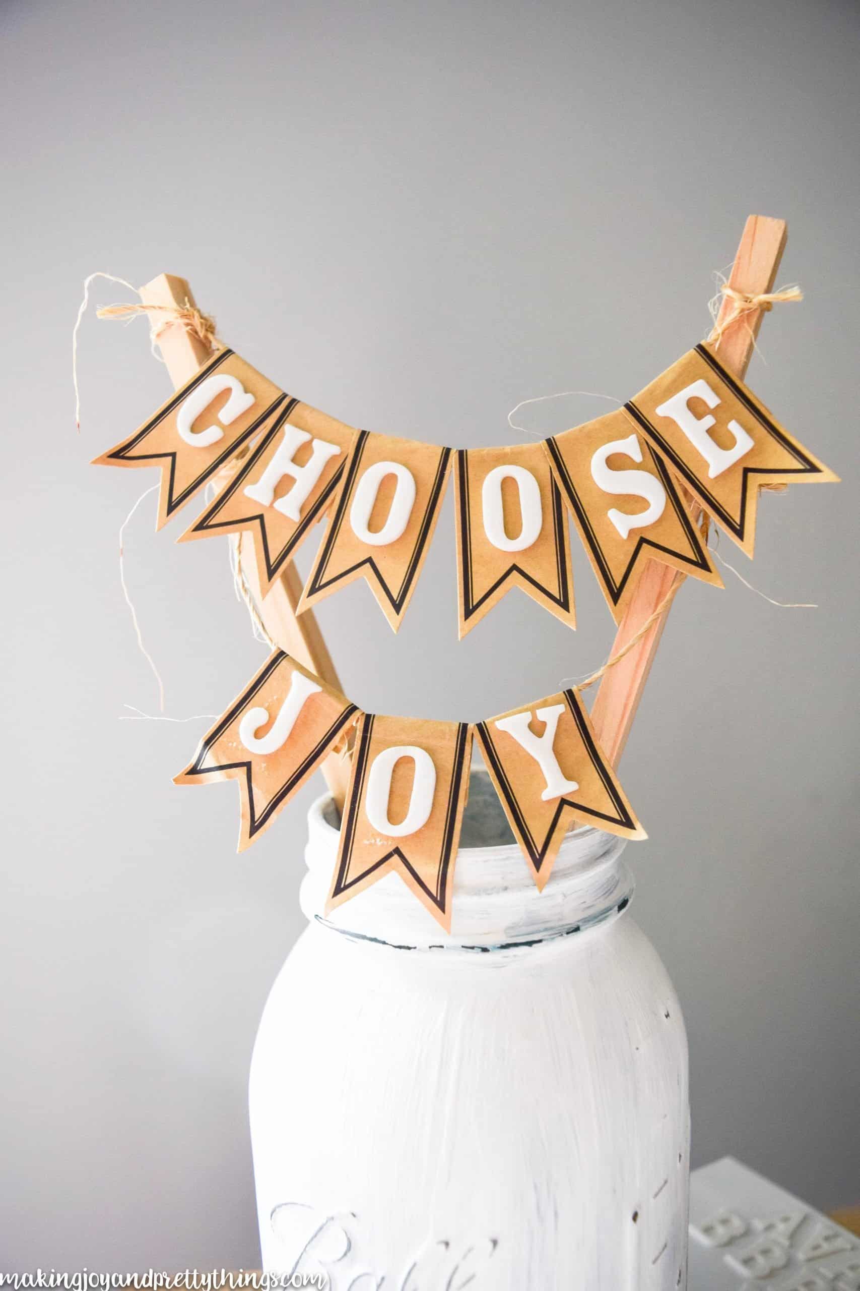 Distressed mason jar displays with an uplifting message strung across twine to put on rustic shelves