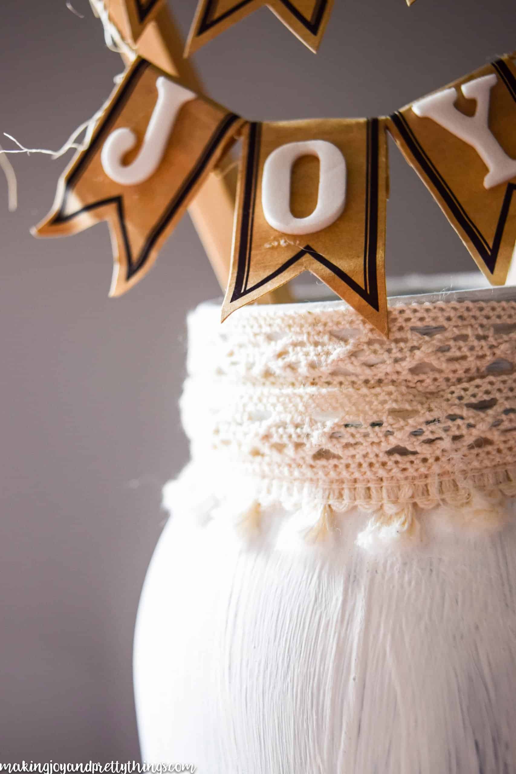 Joy written in foam letters on labels with flags and ivory trim on a mason jar with a farmhouse look