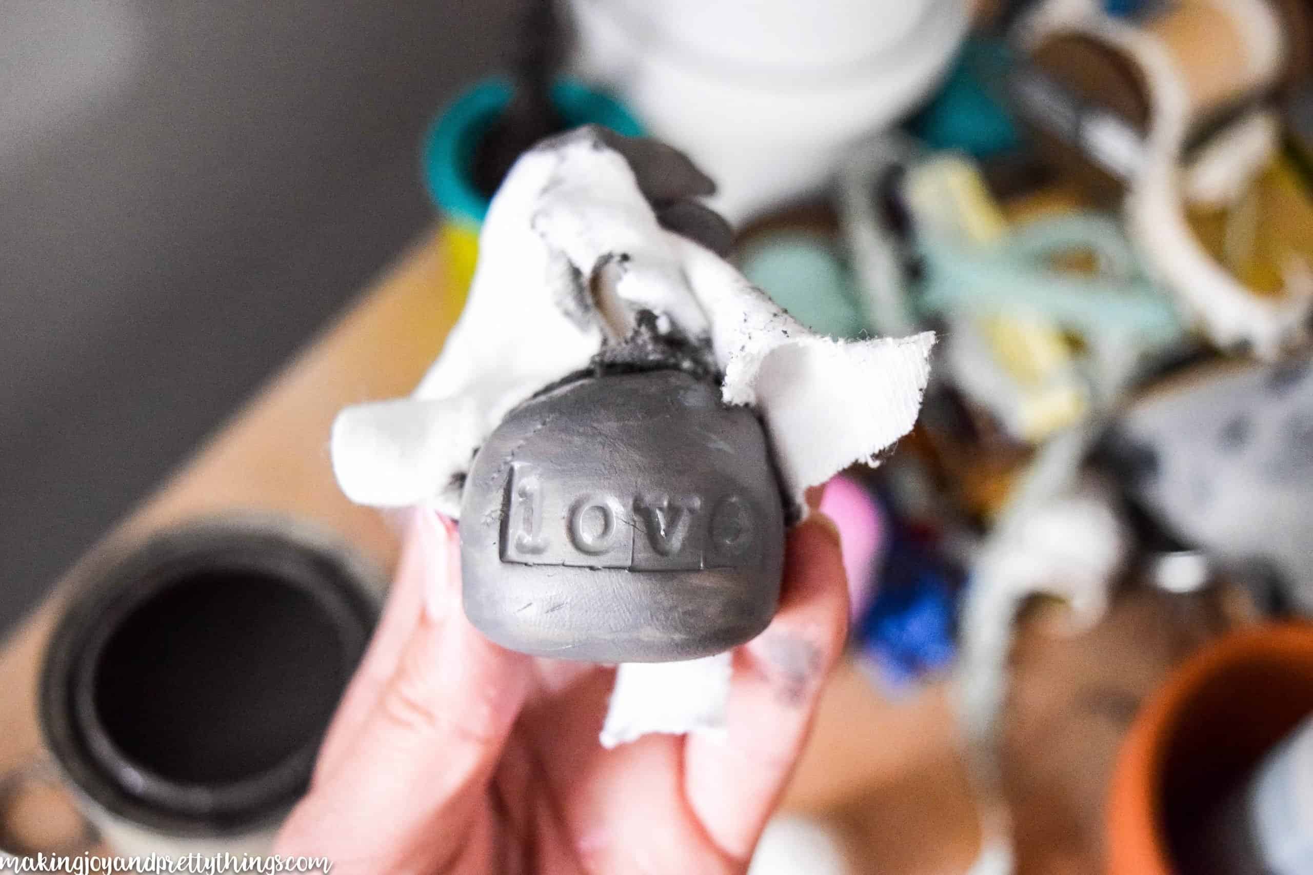 This is a baked clay base for a DIY wire photo holder that has been painted grey and distressed 