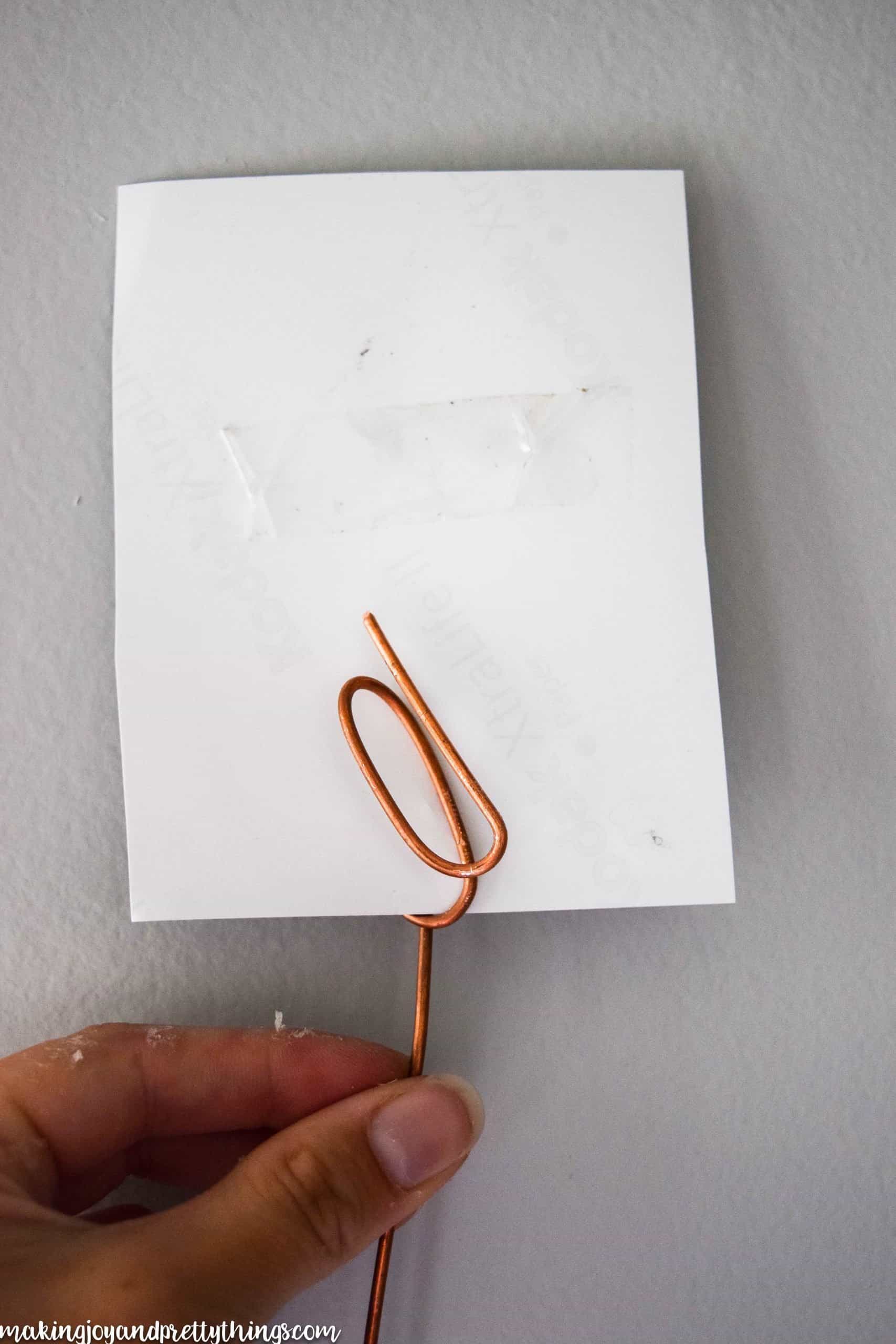 Showing the back of the photo to reveal how the looped copper wire holds the picture