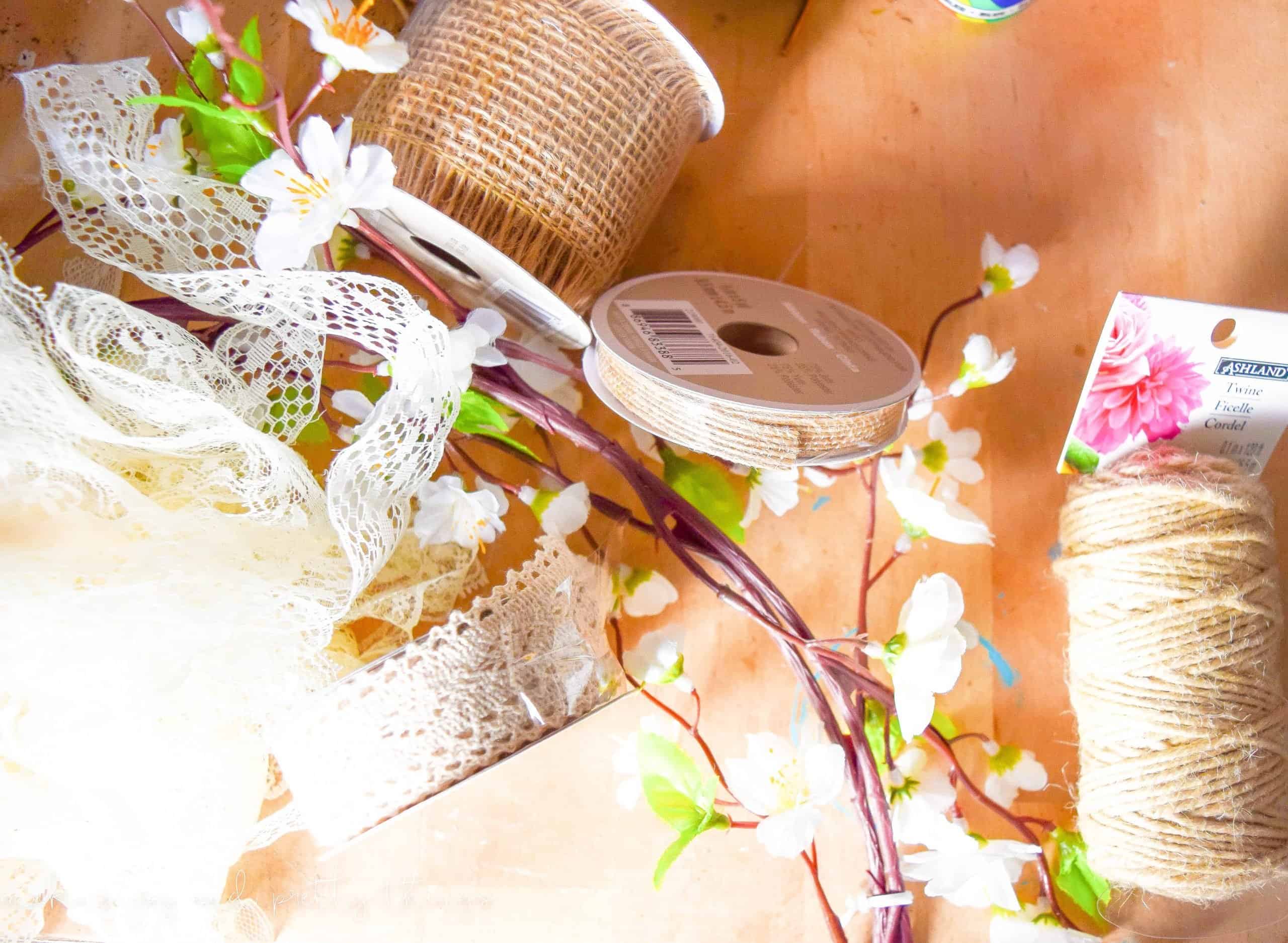 Supplies for a spring mantel garland with lace, flowers, twine to make a farmhouse style