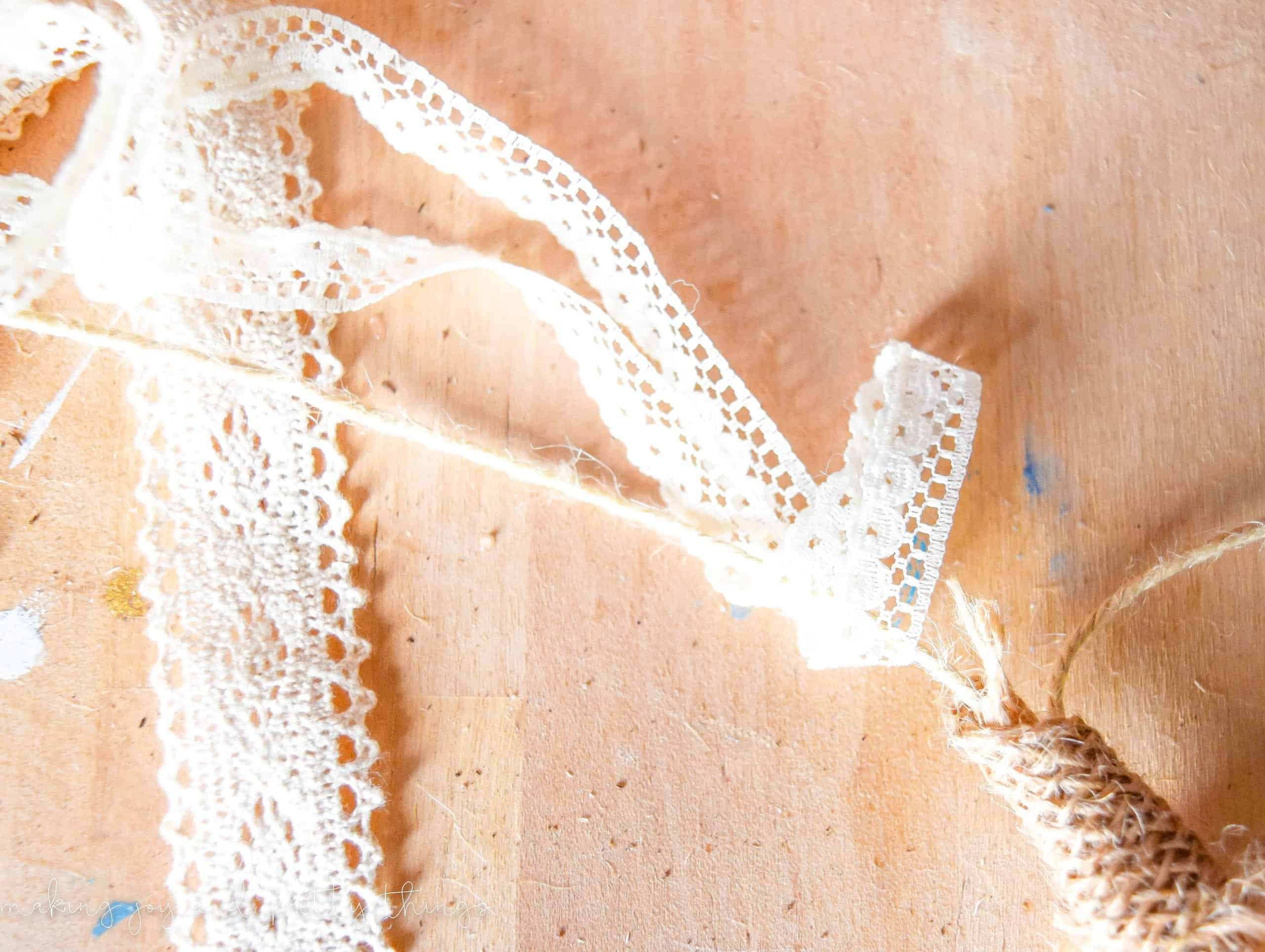 Wrapping lace around twine in order to tie a knot to secure it for a mantel DIY for spring