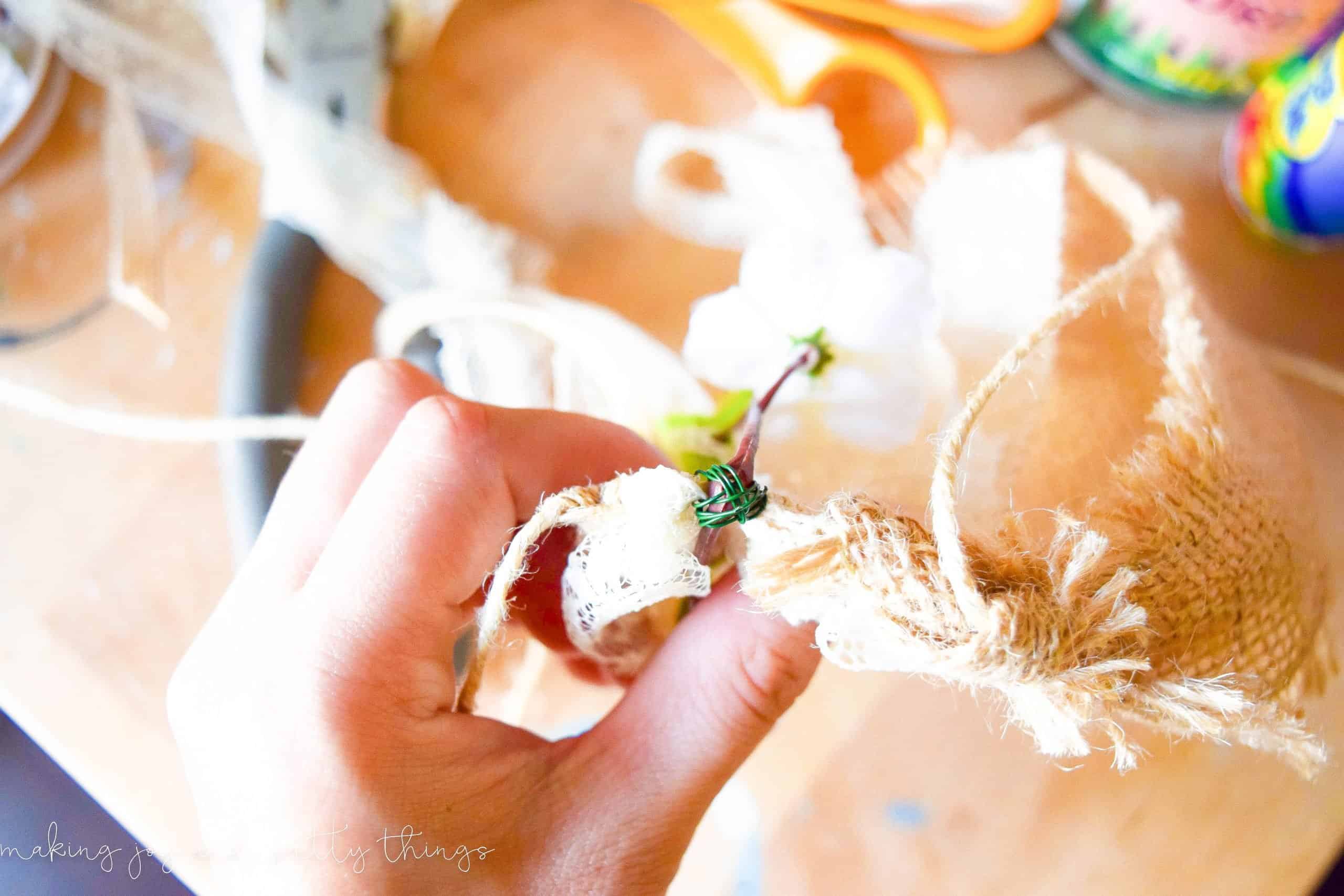 multiple passes and rotations using floral wire to secure flowers to twin for a spring garland mantel