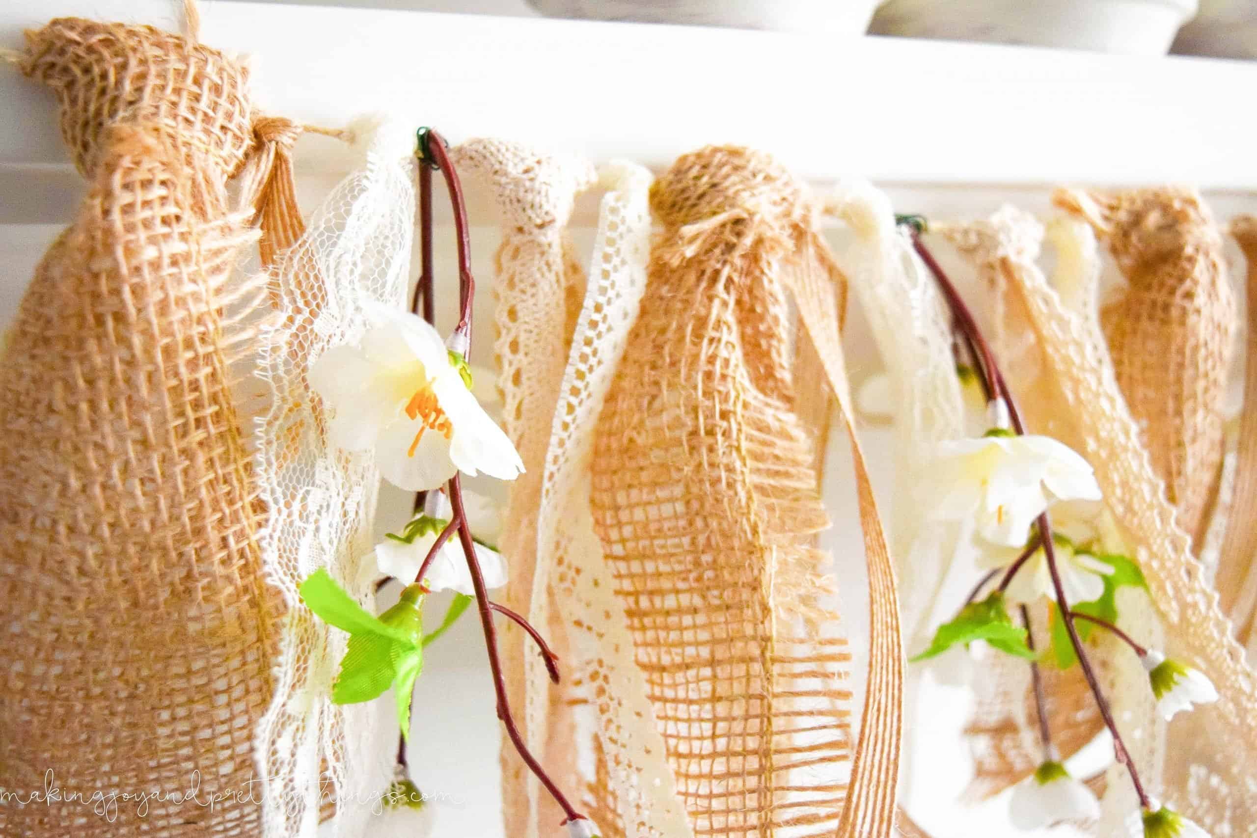 Close up of flowers and other burlap and lace in the spring mantel garland DIY