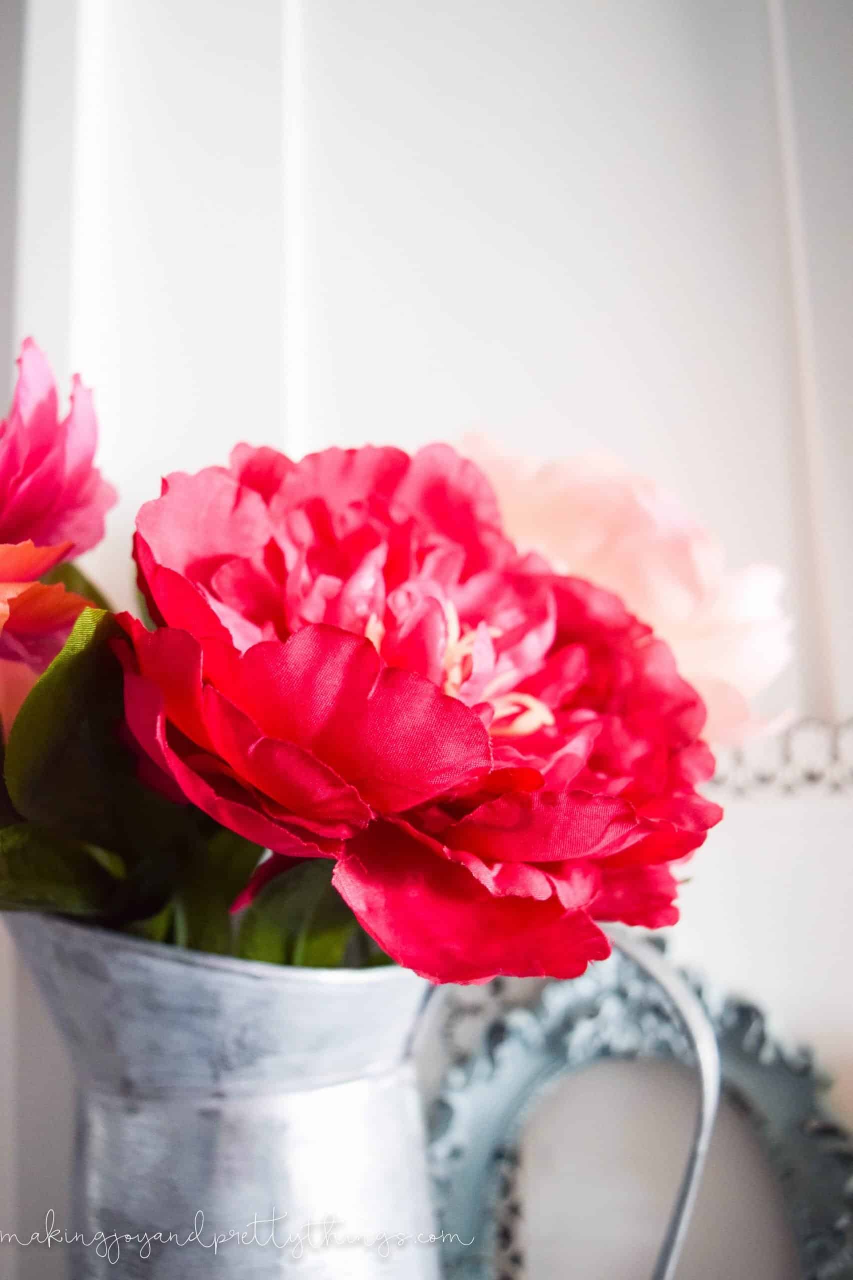 A close up look at the faux pink hydrangea blooms in a galvanized metal vase.