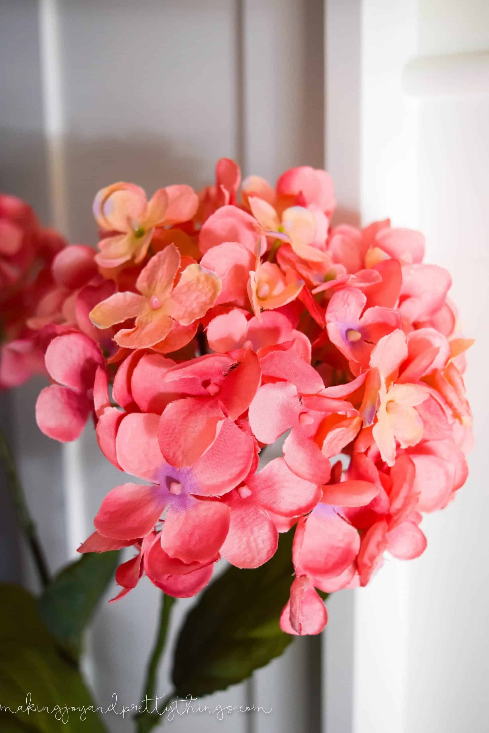 A close up look at the bright pink hydrangea blooms on our summer living room mantle.
