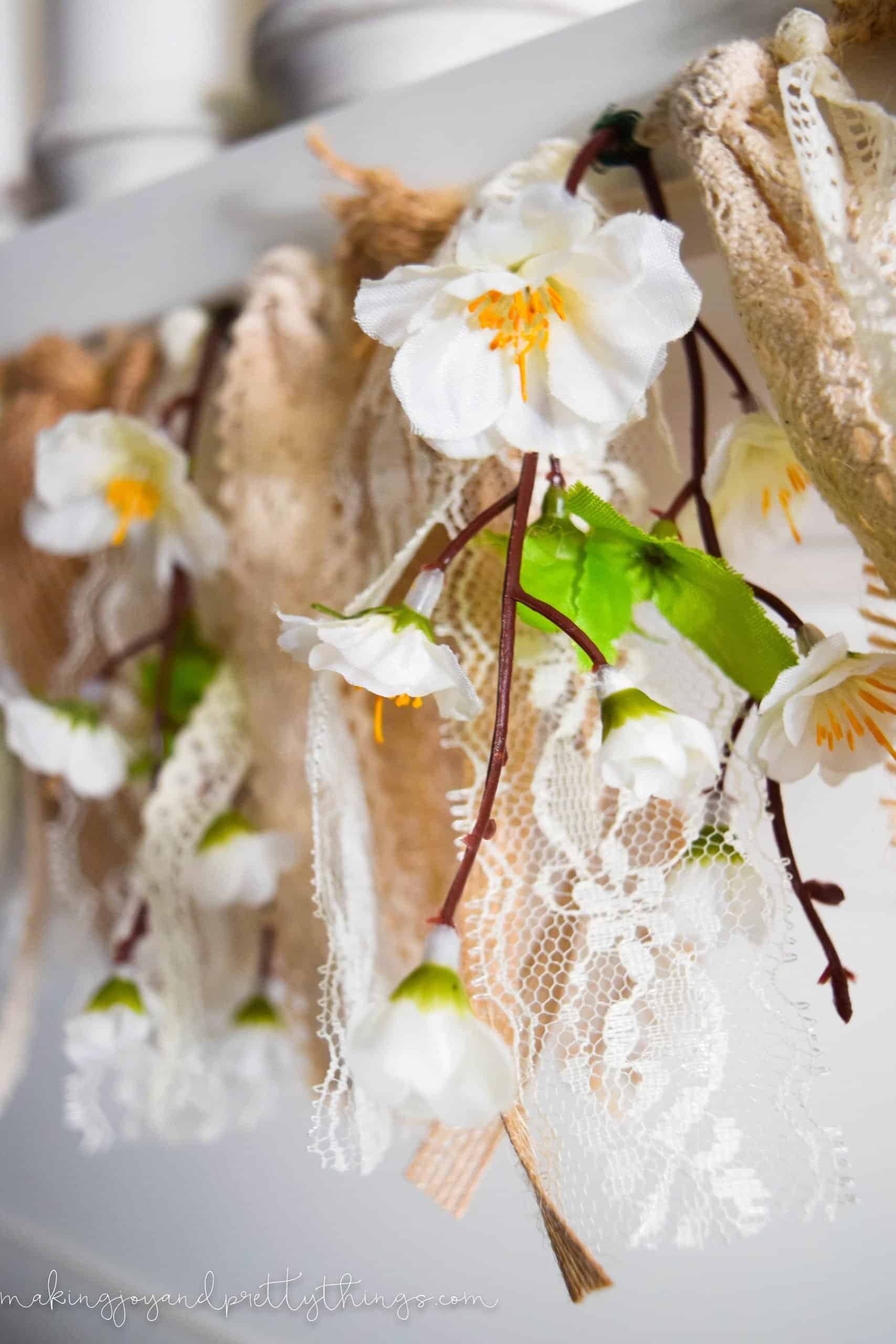 A closer look at the springs of faux peach blossom flowers on a lace garland.