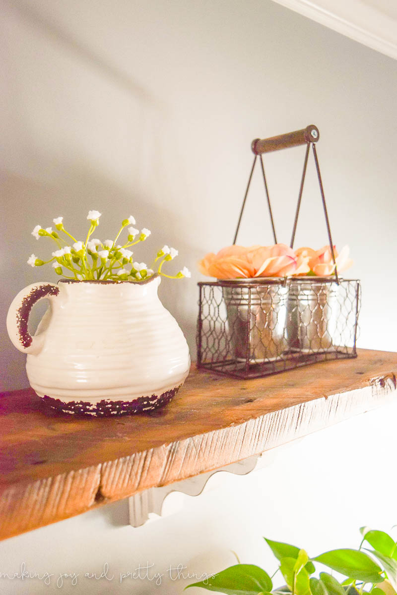 Beautiful floral designs in an old pitcher and chicken wire basket to fill out space on the top of the diy shelves