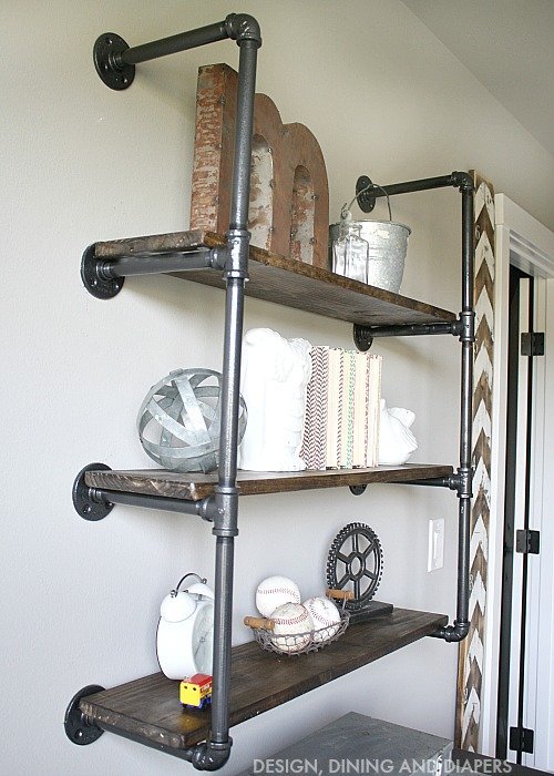 Industrial wall shelves made with pipes and wood styled with vintage decorations and books 