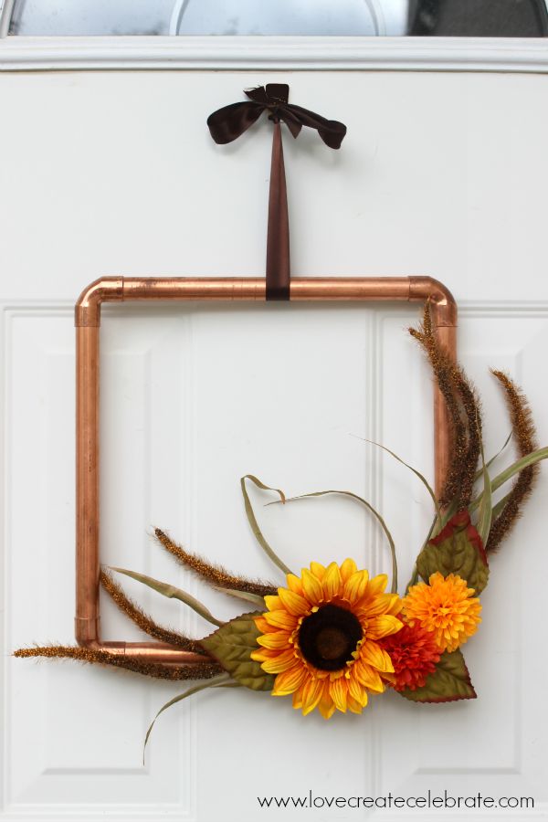 Very unique copper pipe wreath with fall flowers and a truly amazing DIY that puts a new spin on fall