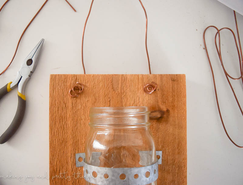 Using copper to complete this hanging mason jars on wood is a simple and decorative way to hang this decor