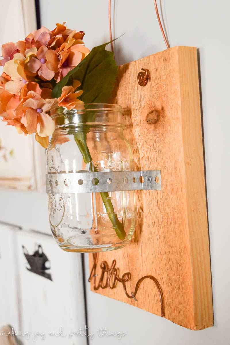 Adding a floral touch do the hanging mason jars on wood completes this look and looks great hung on a wall