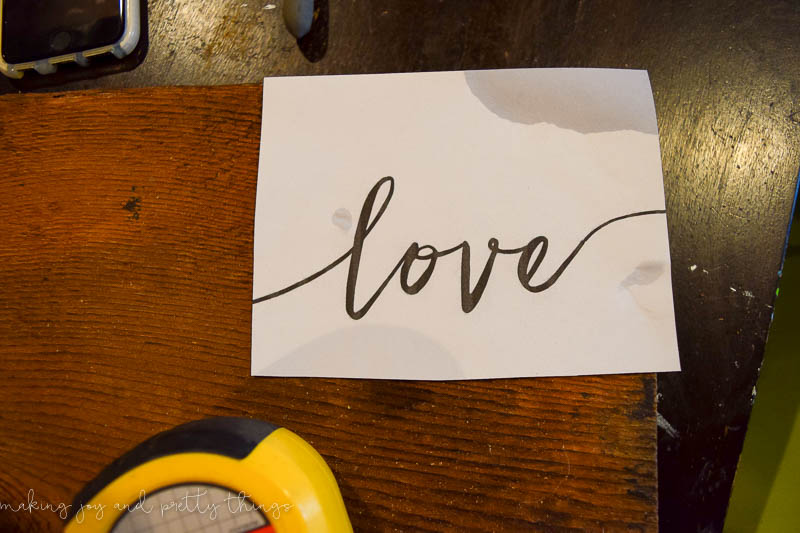 Using a printable word love to trace with copper wire and attach to the hanging mason jars on wood DIY
