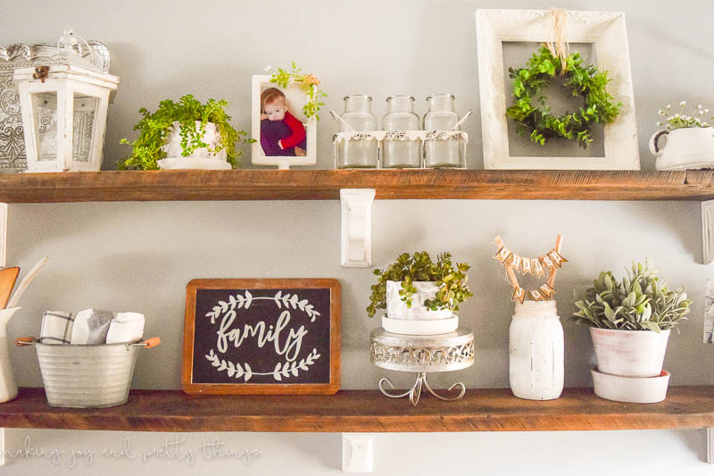 Rustic farmhouse shelves decorated in various farmhouse style decorations with floral and distress touches