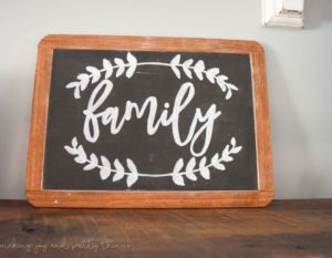 A wood framed chalkboard sign with the word "family" written in white chalk