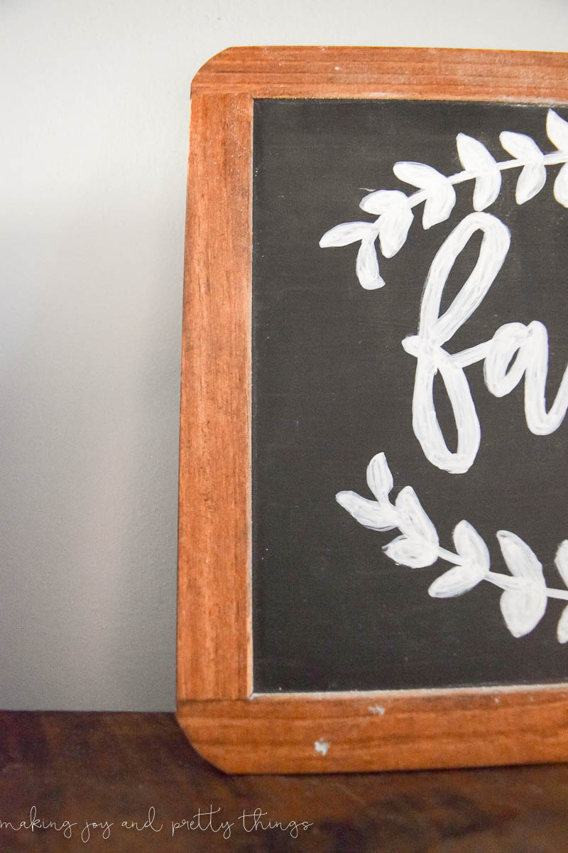 DIY chalkboard lettering filled in with chalk paint to finish a craft for rustic shelving in a farmhouse style