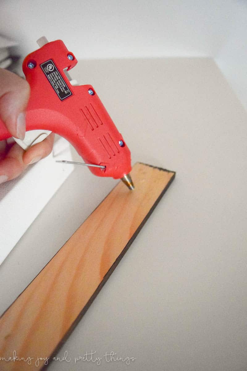 Using a glue gun to attach a stained pine wood frame to a canvas is a great ideas to add decor to your home