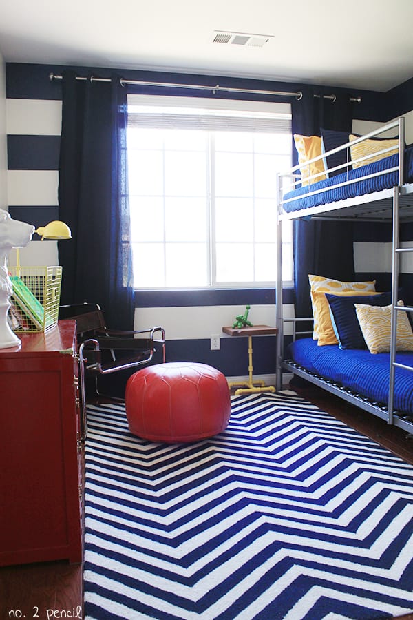 a Blue themed share kids room with striped decorations and matching bunk beds 