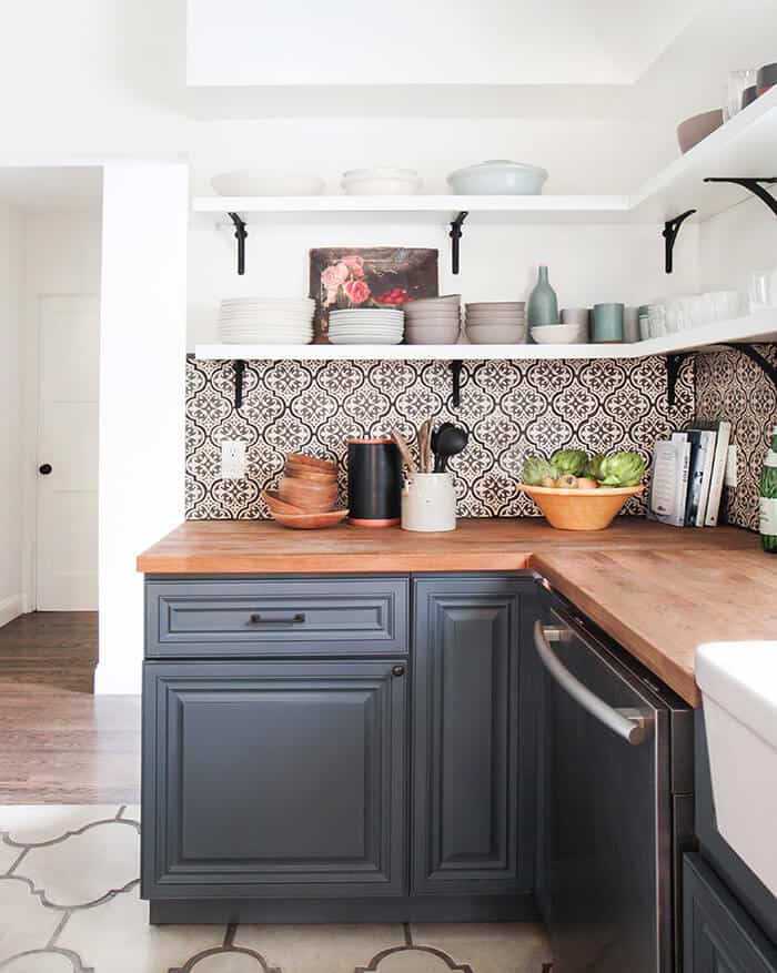 I love this Cement tile backsplash in the moody spanish style kitchen renovation with open shelving from Emily Henderson