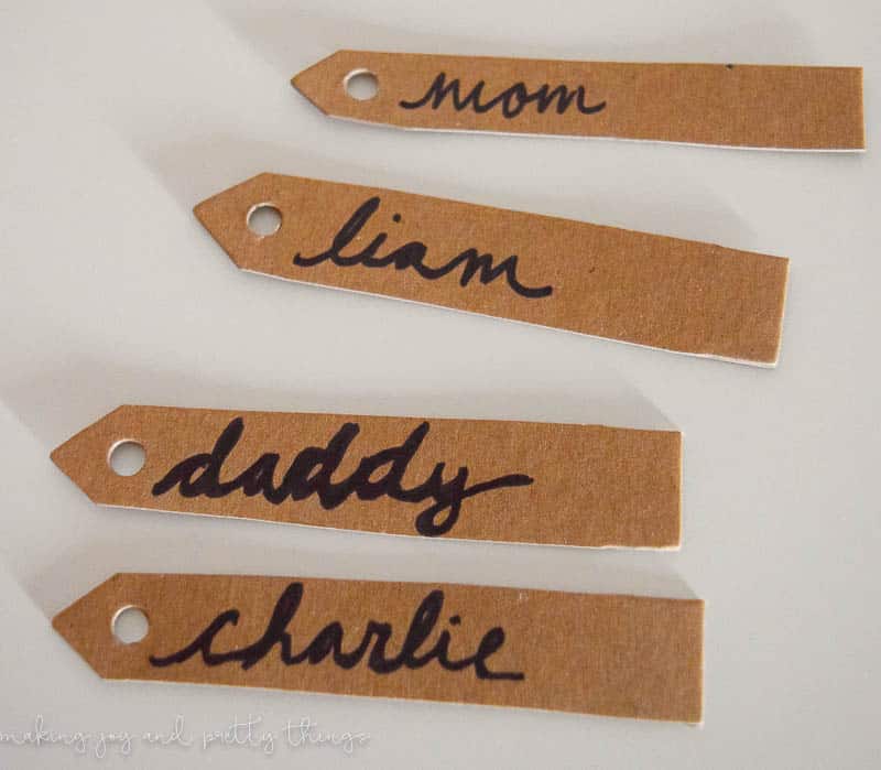 Four gift tags with hand-written names - mom, liam, daddy, and charlie - written in black permanent marker.
