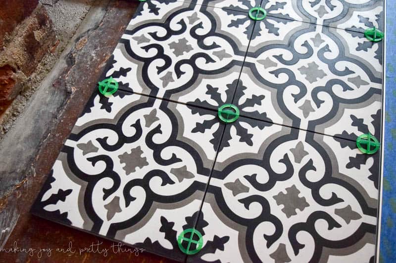 A close up look at the black, white, and gray cement tiles and the tile spaces we used when installing cement tiles in our fireplace hearth.