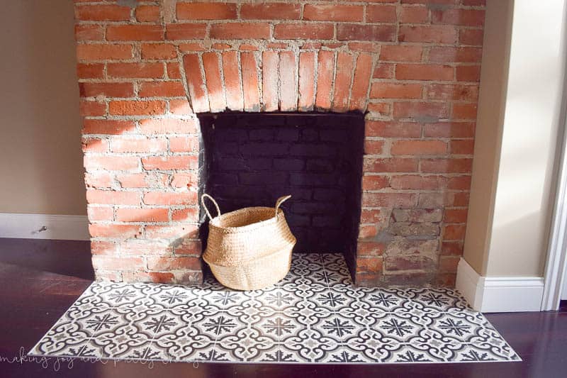The completed fireplace hearth with cement tiles and painted background! I love the look of these black and white patterned tiles with the natural brick fireplace.