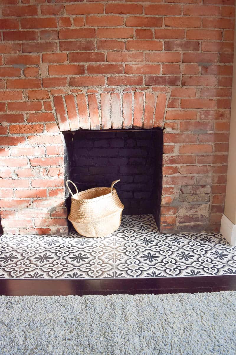 A look at our exposed brick fireplace, after installing black and white patterned cement tiles, and the interior of the fireplace painted black.