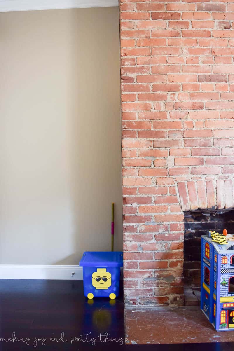 Our exposed brick fireplace - surrounded by kids toys - before installing the cement tile hearth.