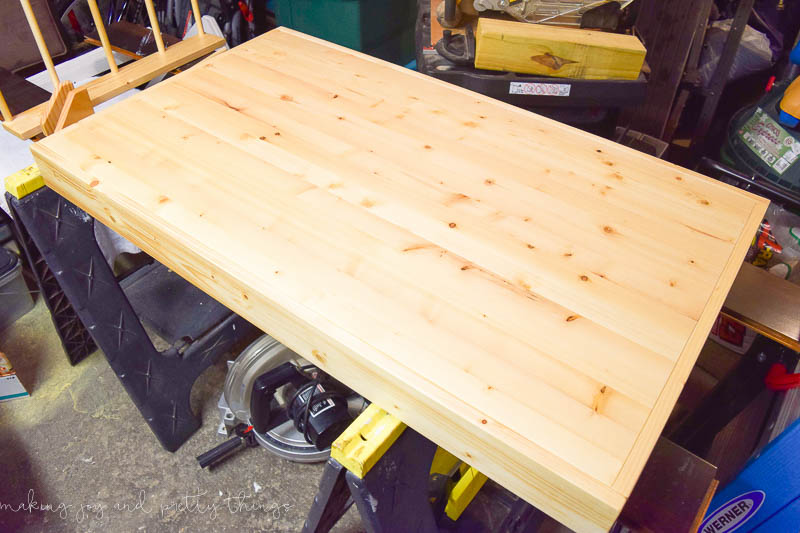 Building the table top for our kids craft table made with unstained pine wood.