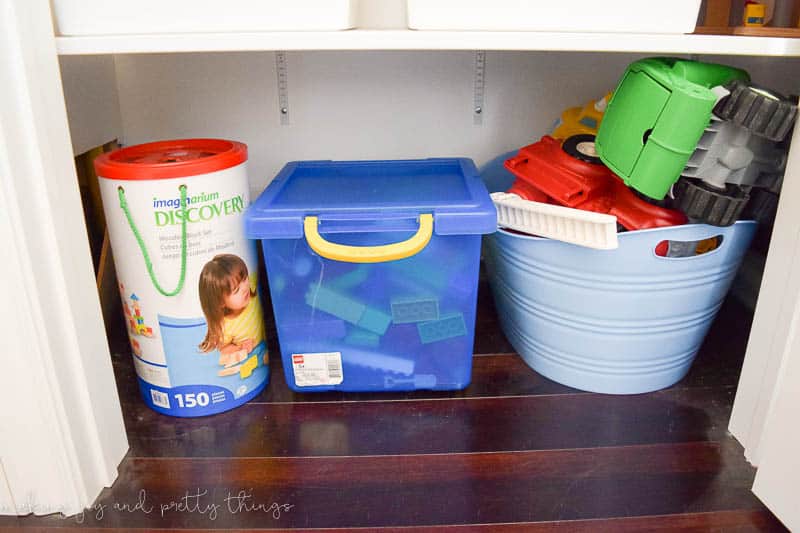 A photo of a blocks, Legos and trucks.  Each is in its own bin and all accessible to both boys.