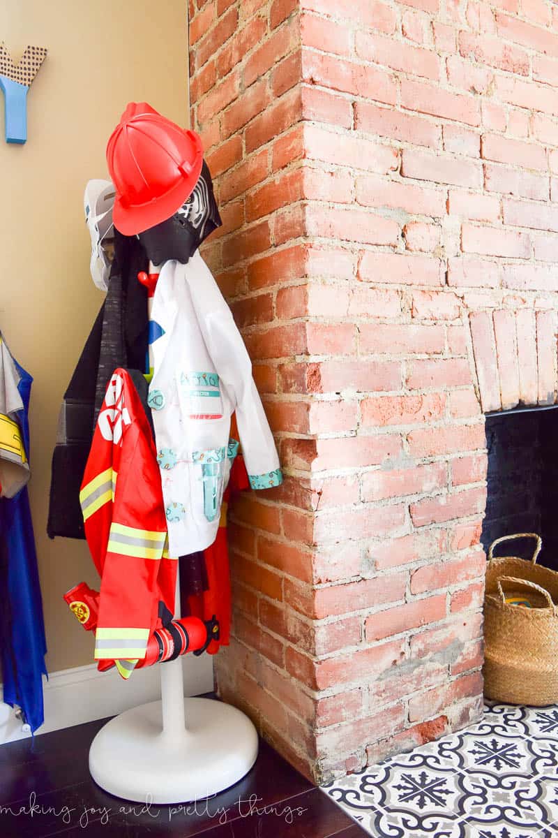 A photo of a cute dress-up storage area for boys, with hooks on the wall to hang costumes.