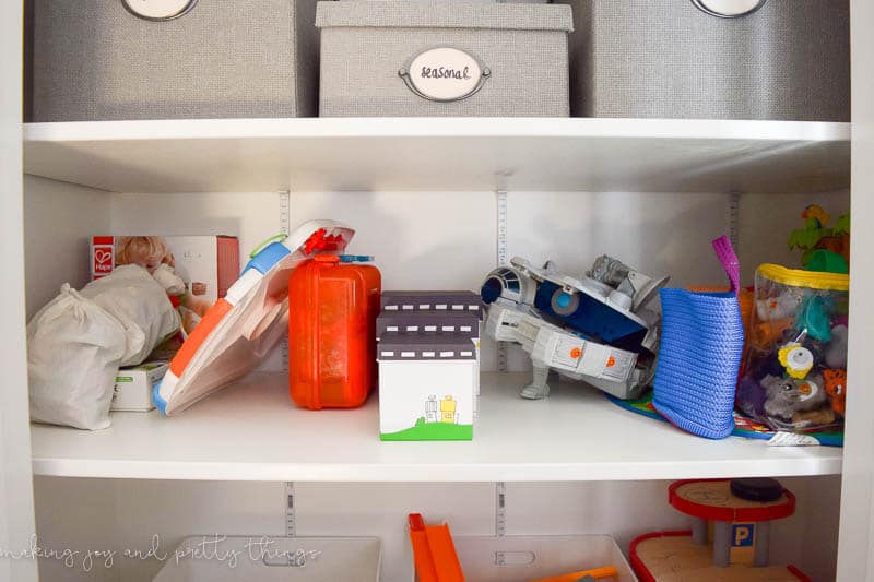 A photo of the second shelf in a cabinet shows toys.