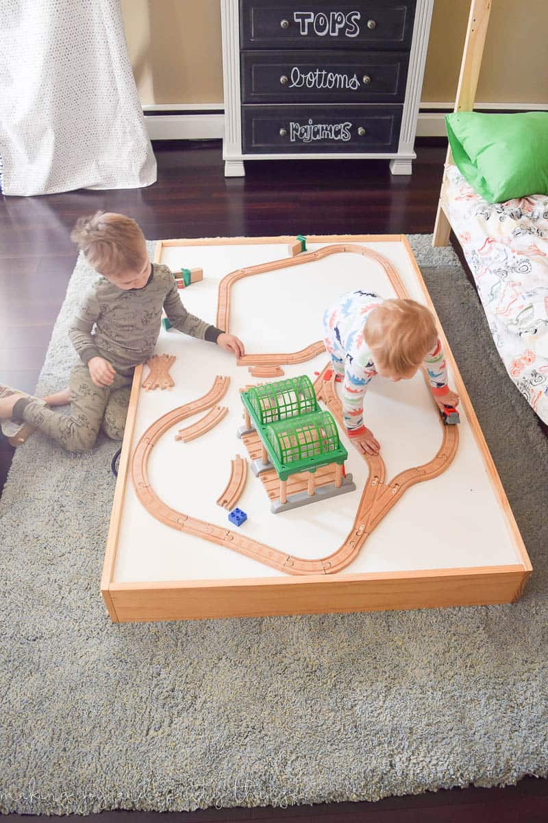 Another photo of Under bed storage with a train table and two boys playing in the photo.