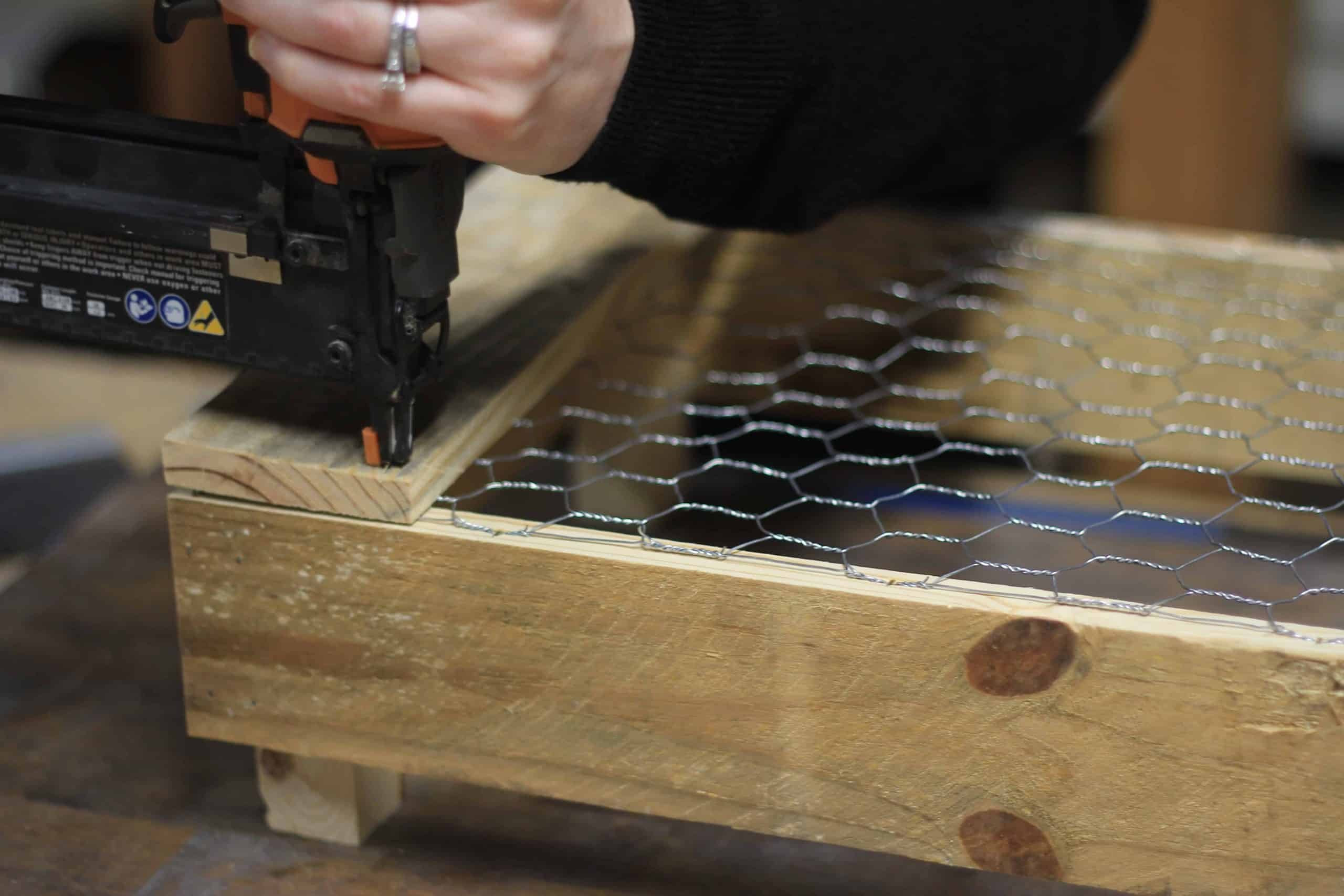 Once the chicken wire is secured with staples you can ad the bottom supports with a brad nailer to finish up the base of the DIY pallet crate
