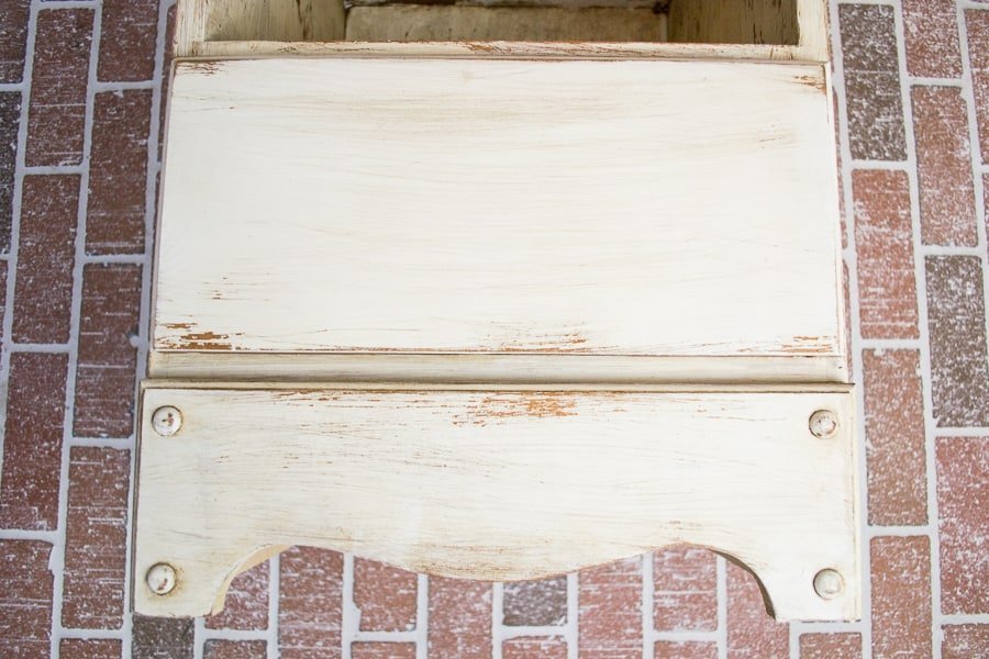 Once your piece is waxed, work the wax into the furniture and chalk paint to distress the furniture more