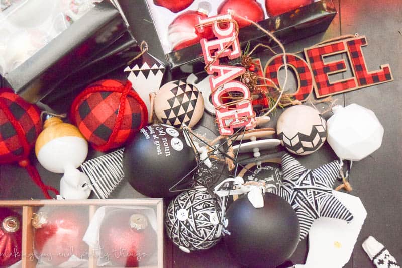A pile of Christmas ornaments of various sizes, shapes, and patterns. The color palette is red, black, and white.